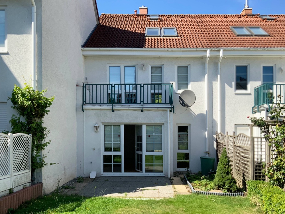 Gartenansicht mit Terrasse und Balkon